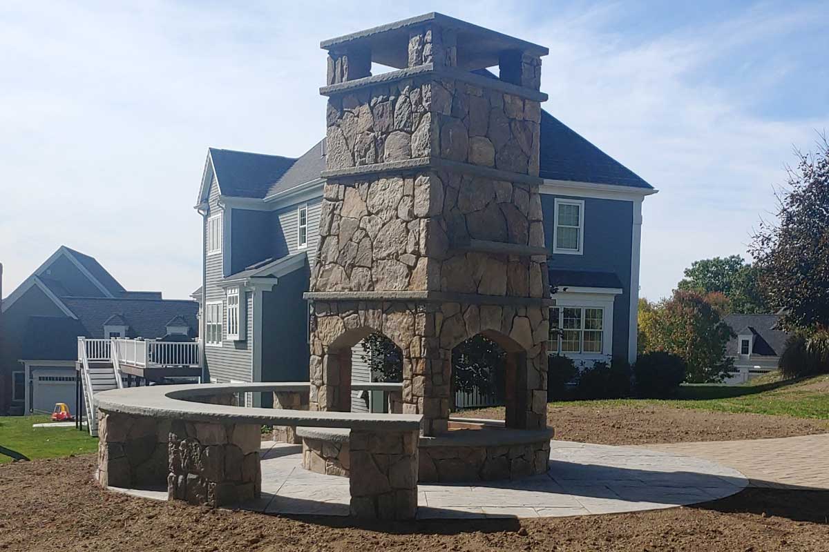 Four-sided outdoor fireplace with overlay of hand-cut New England fieldstone