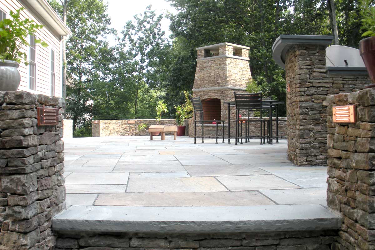 The Natural Landscape Inc. – Pennsylvania fieldstone walls, grill and fireplace. Jet Mist granite countertop with antique finish.  Natural cleft bluestone patio